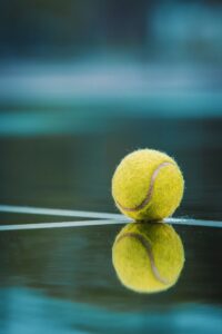 A reflection of a tennis ball on a court