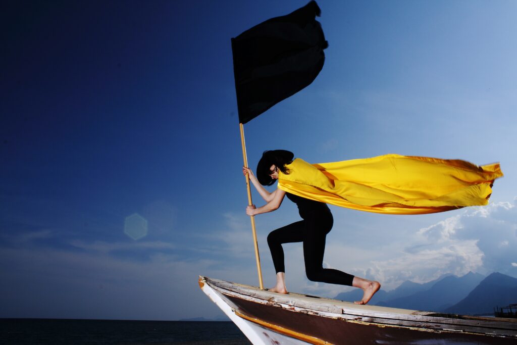 A phone of women putting up a flag with a cape on