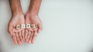 hands hold blocks spelling give